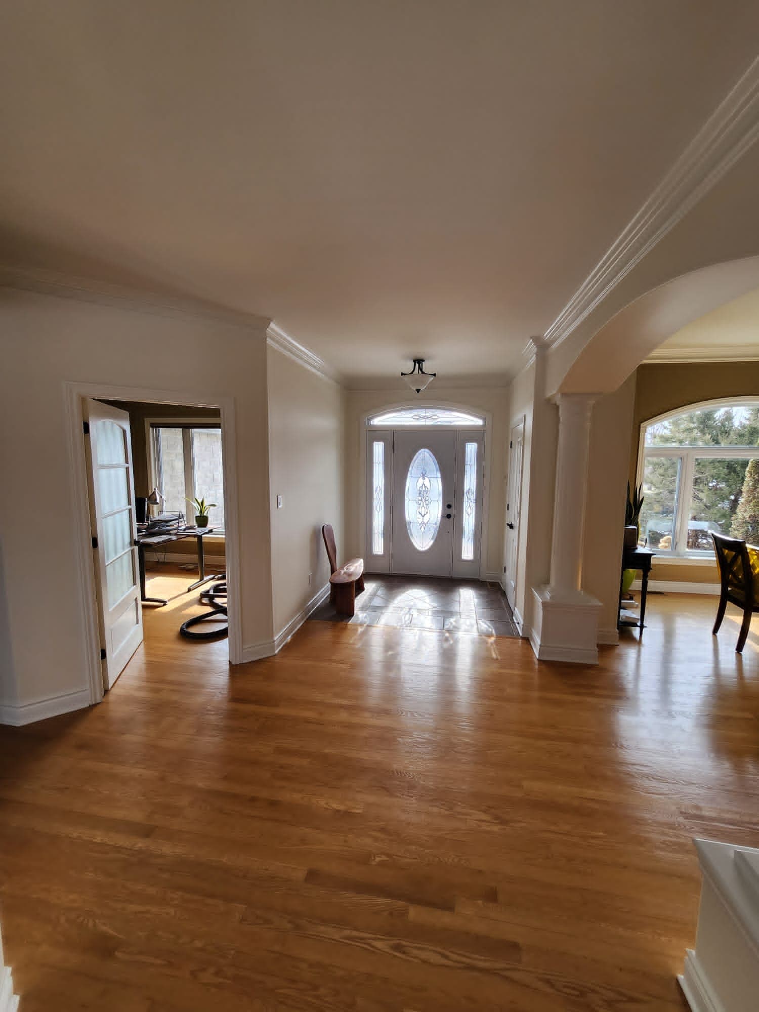 Grand entrance foyer with curved archway and hardwood floors in Ottawa home
