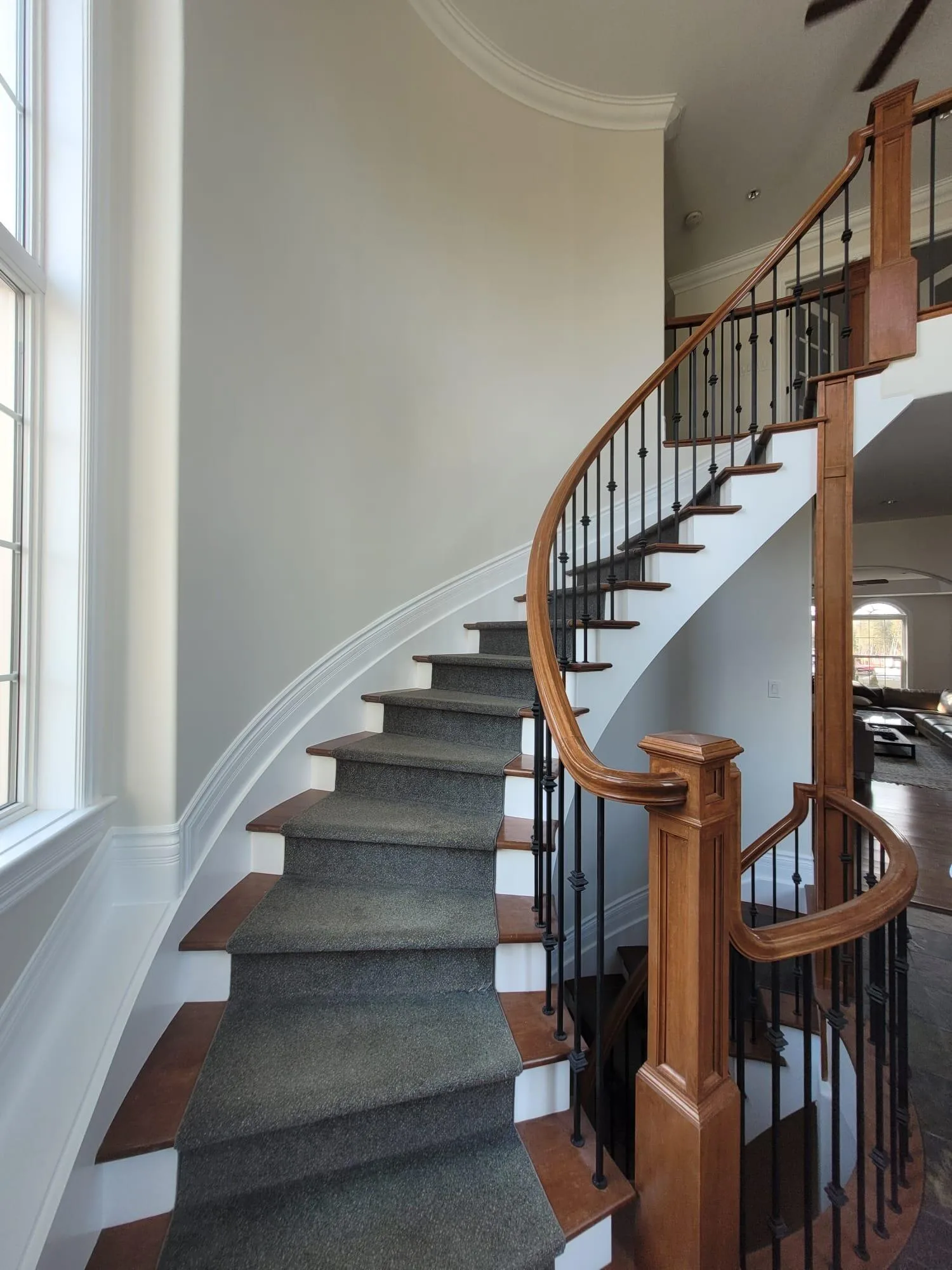 Staircase detail showing precision paint finish on hardwood and custom railings