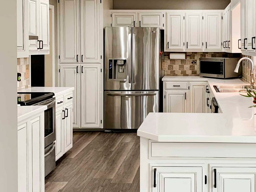 Ottawa kitchen after cabinet refinishing - white cabinets with black hardware and stone countertops